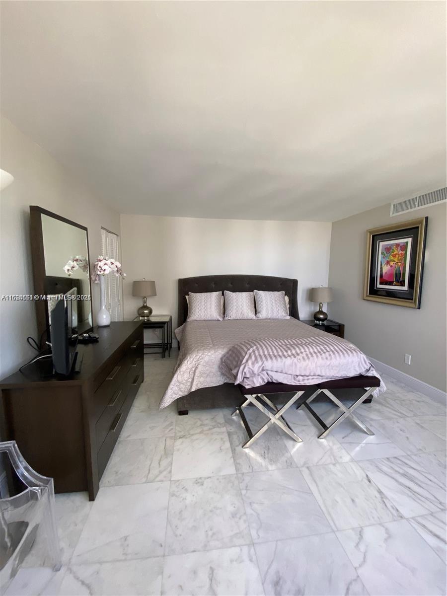 2800 North Ocean Drive, Unit B15C Riviera Beach, FL 33404 - Photo 10 of 32 a spacious bedroom with a bed and wooden floor