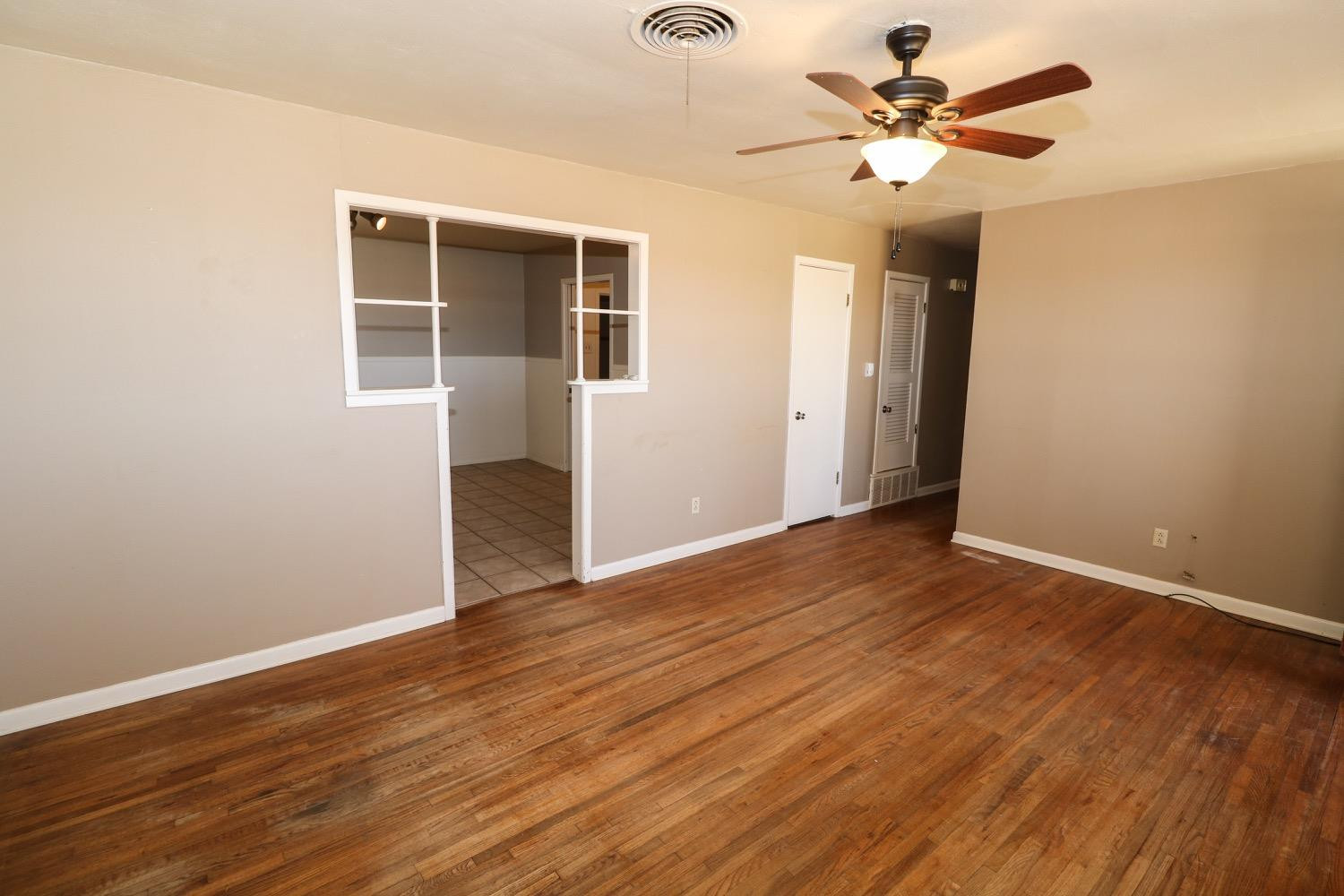 450 County Road 29 Muleshoe, TX 79347 - Photo 4 of 27 a view of an empty room with wooden floor and a ceiling fan