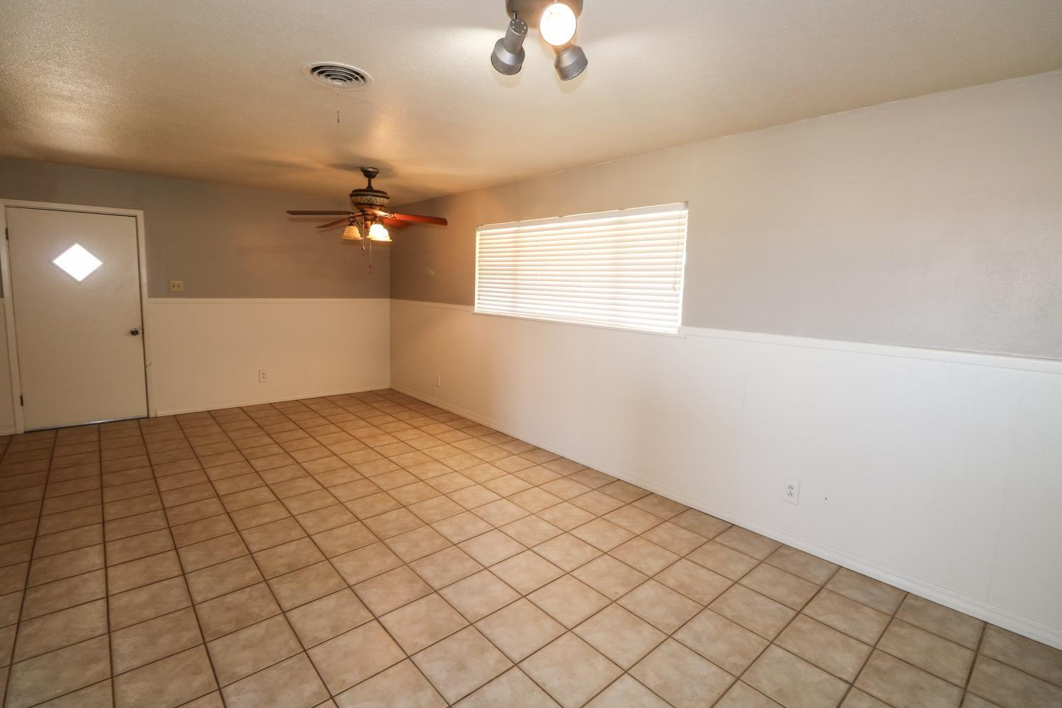 450 County Road 29 Muleshoe, TX 79347 - Photo 9 of 27 an empty room with chandelier fan and windows