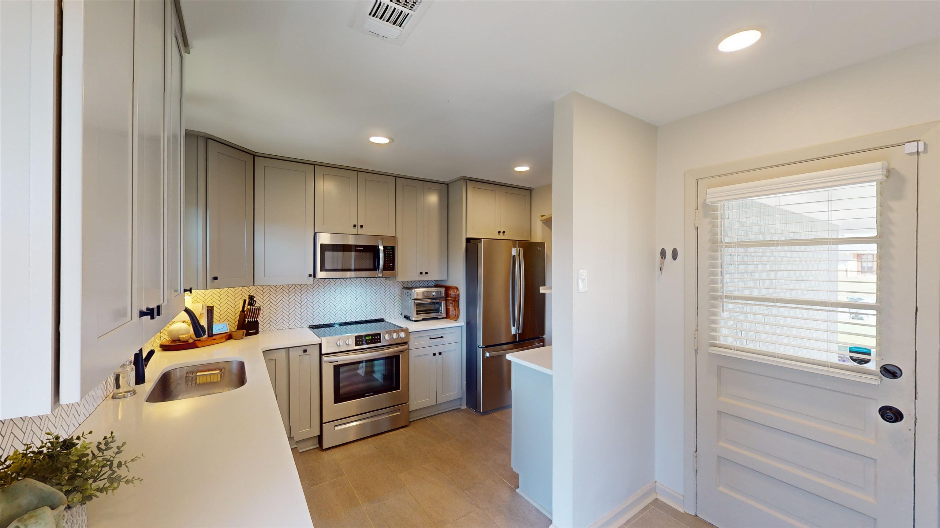 4779 Dee Road Memphis, TN 38117 - Photo 15 of 35 a kitchen with stainless steel appliances granite countertop a refrigerator a stove a sink and a microwave