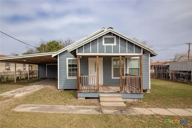 a front view of a house with a yard outdoor seating and garage