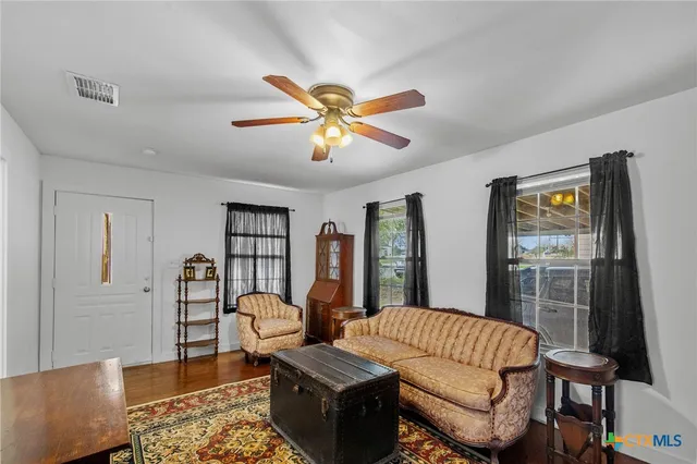 a living room with furniture a ceiling fan and a rug