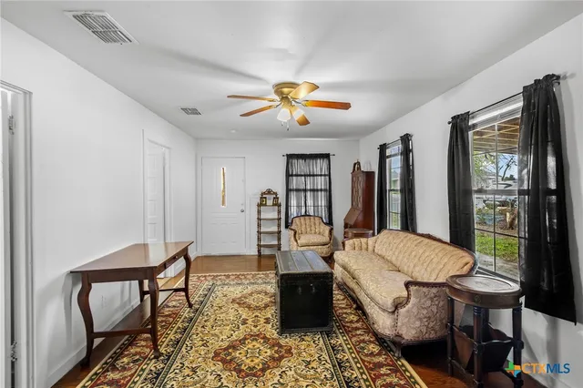 a living room with furniture a chandelier and a rug