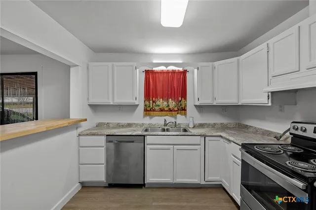 a kitchen with cabinets appliances a sink and a counter top space