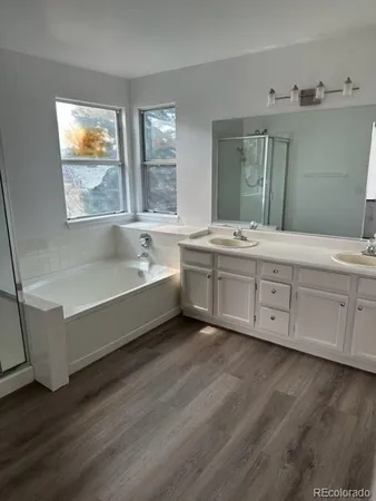 a bathroom with a double vanity sink a mirror and a bathtub