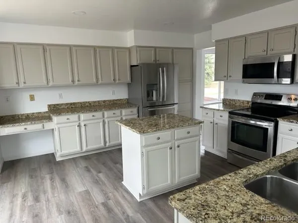 a kitchen with a sink stove and microwave