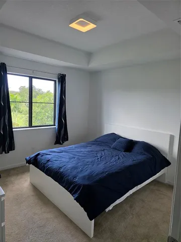 a bed sitting in a bedroom next to a window