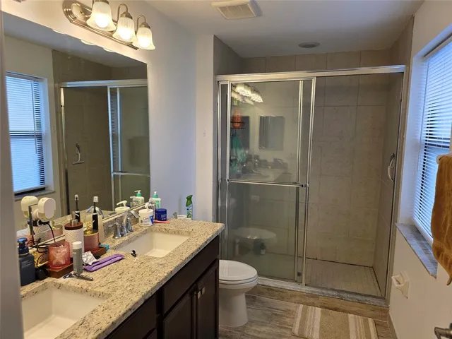 a bathroom with a granite countertop sink toilet and shower
