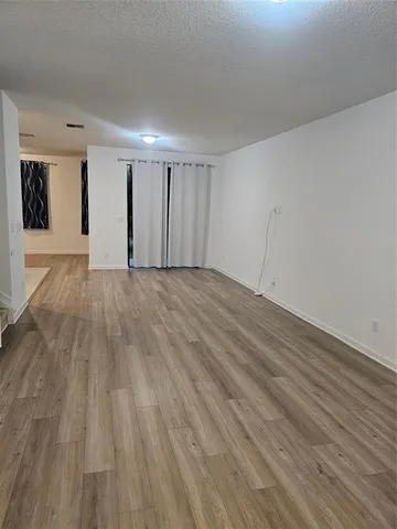 a view of an empty room and wooden floor