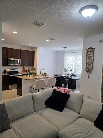 a living room with furniture kitchen view and a window
