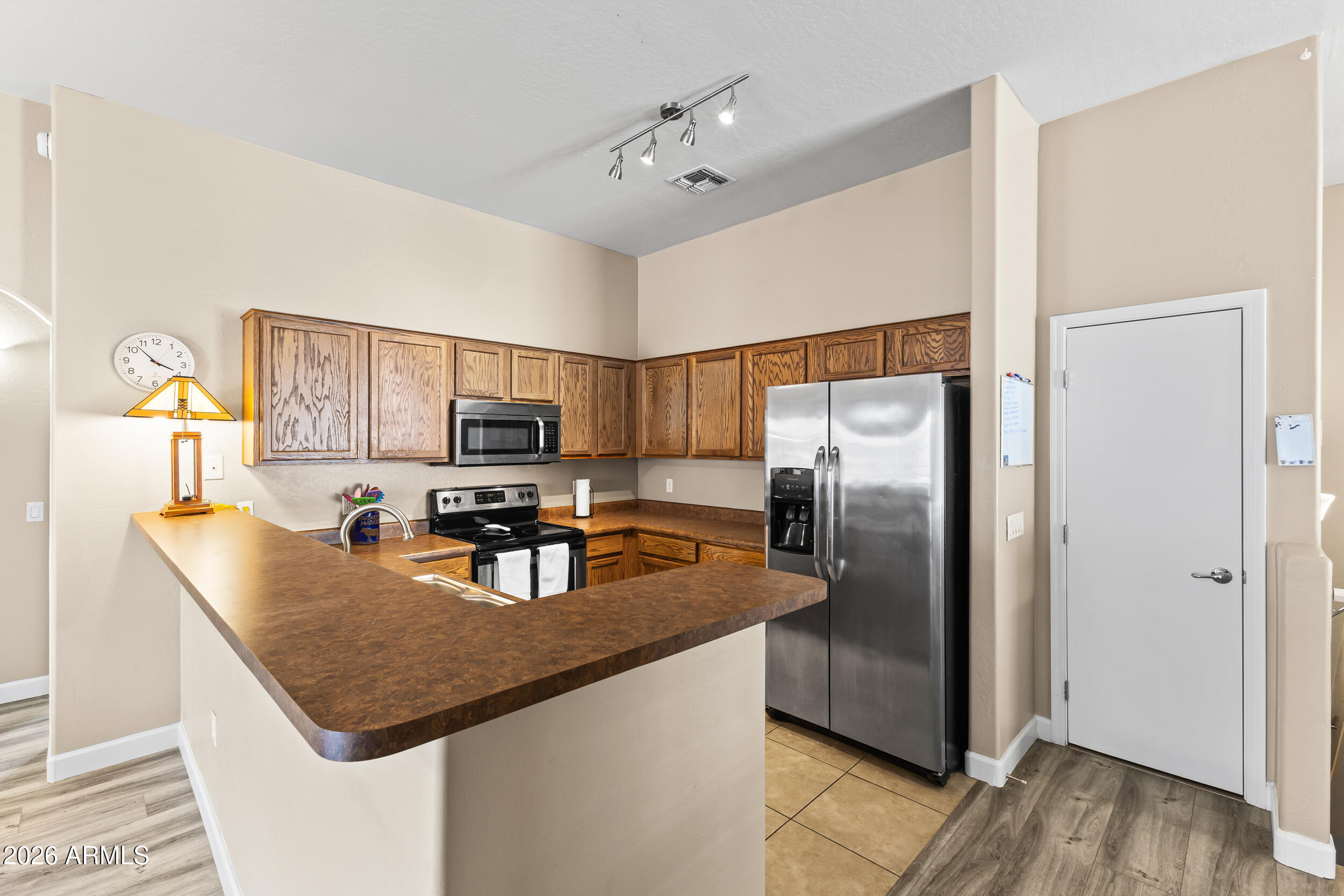 2150 East Bell Road, Unit 1140 Phoenix, AZ 85022 - Photo 2 of 21 a kitchen with kitchen island granite countertop stainless steel appliances a sink stove and refrigerator