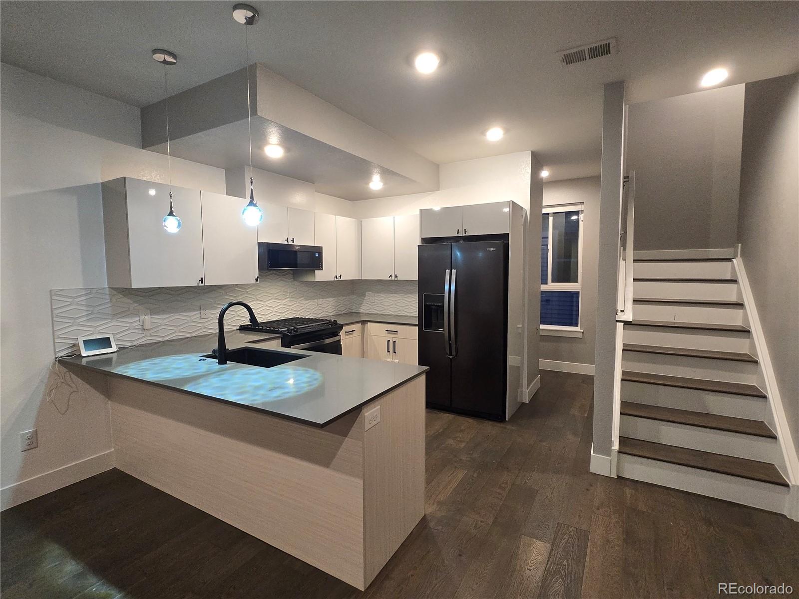 1284 Stuart Street Denver, CO 80204 - Photo 11 of 43 a kitchen with stainless steel appliances granite countertop a refrigerator and a sink
