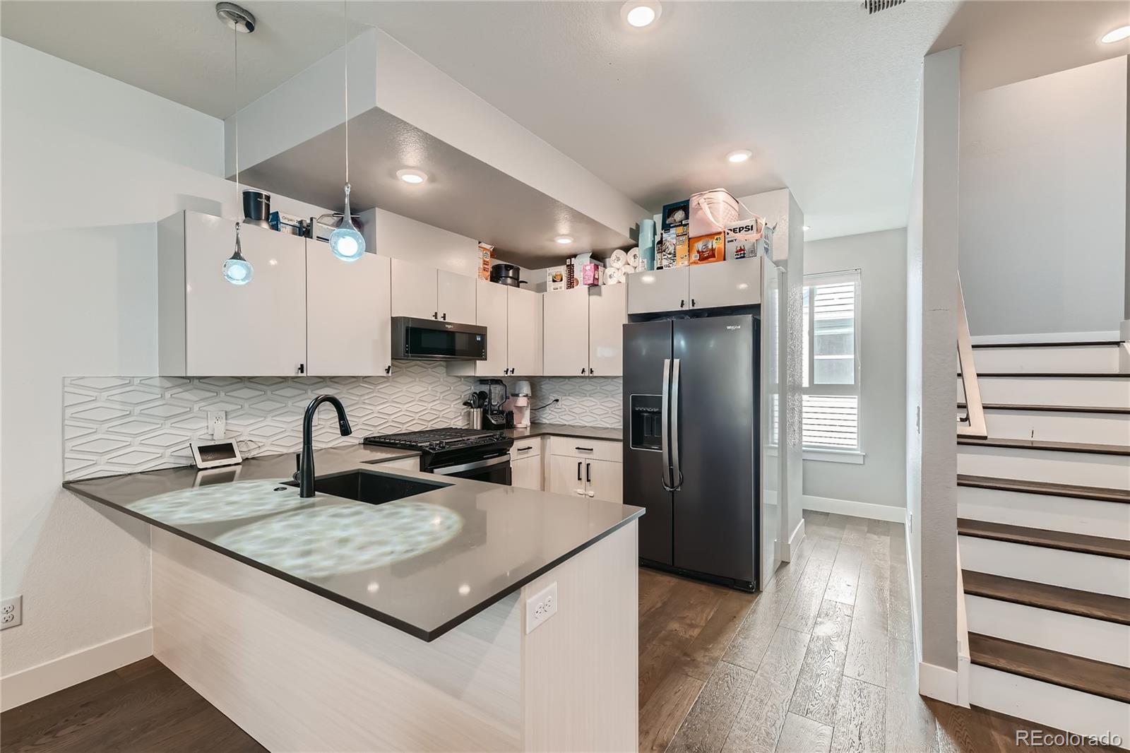 1284 Stuart Street Denver, CO 80204 - Photo 12 of 43 a kitchen with refrigerator and cabinets