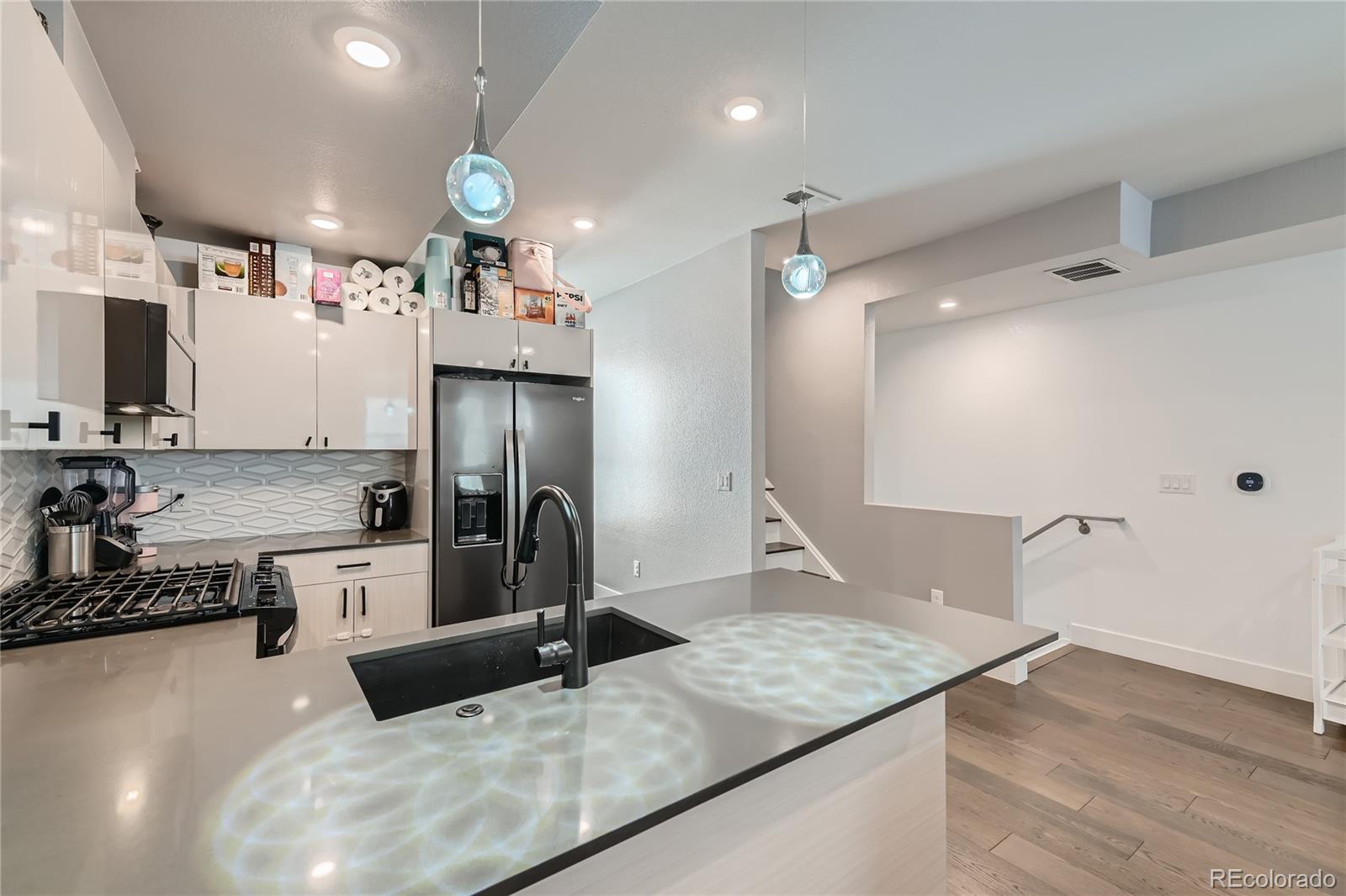 1284 Stuart Street Denver, CO 80204 - Photo 15 of 43 a kitchen with stainless steel appliances granite countertop a sink refrigerator and cabinets