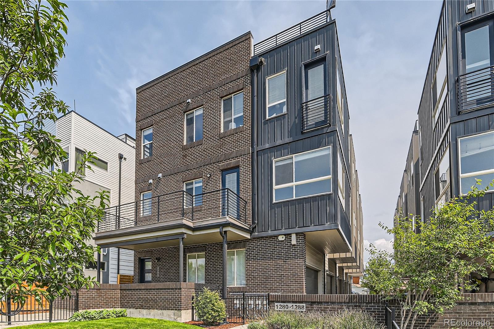 1284 Stuart Street Denver, CO 80204 - Photo 3 of 43 a view of a brick building with large windows and a small yard