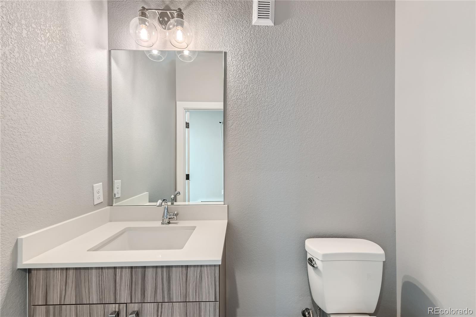 1284 Stuart Street Denver, CO 80204 - Photo 6 of 43 a bathroom with a toilet sink and mirror