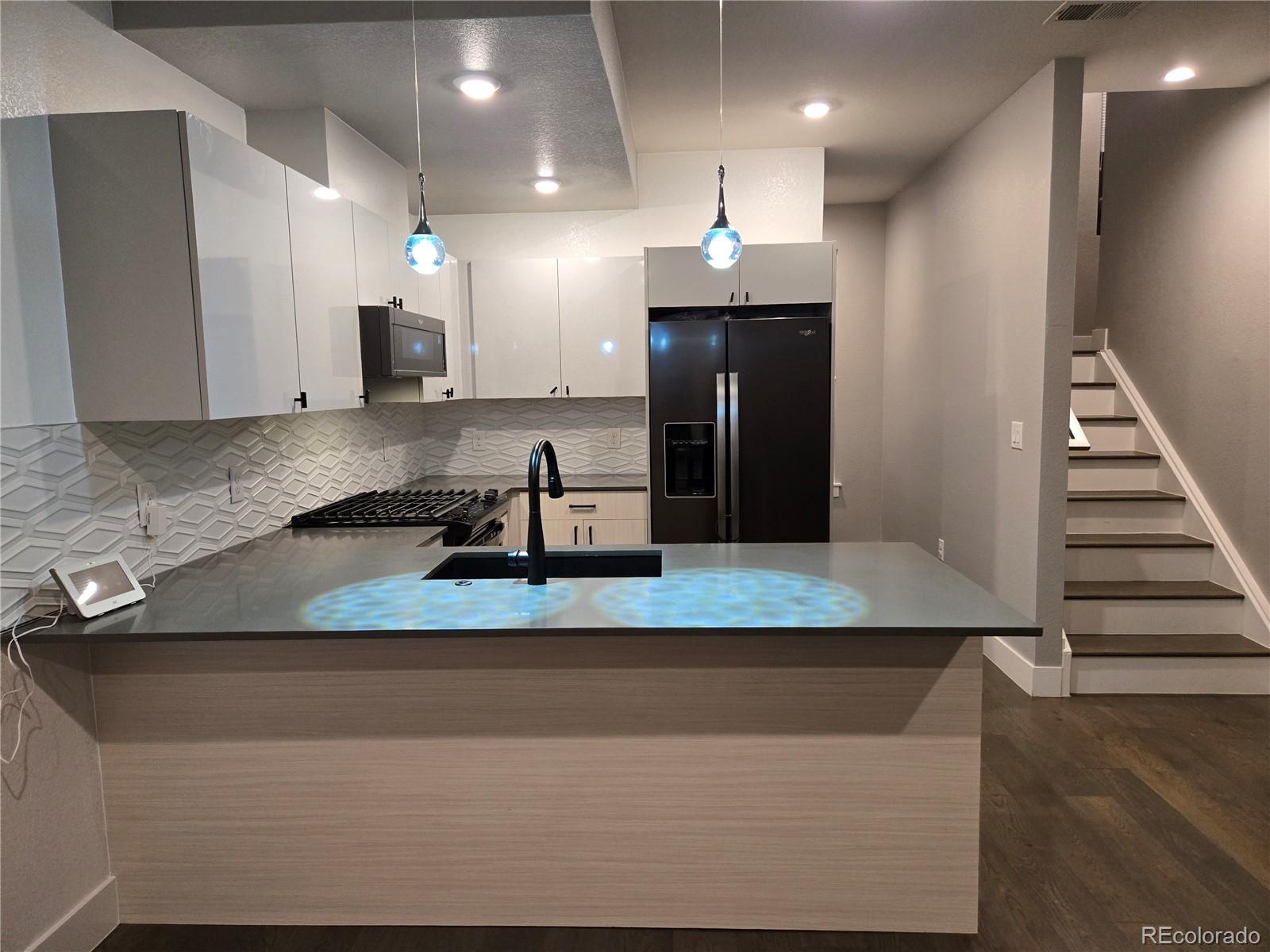 1284 Stuart Street Denver, CO 80204 - Photo 8 of 43 a view of a kitchen with a sink and a refrigerator