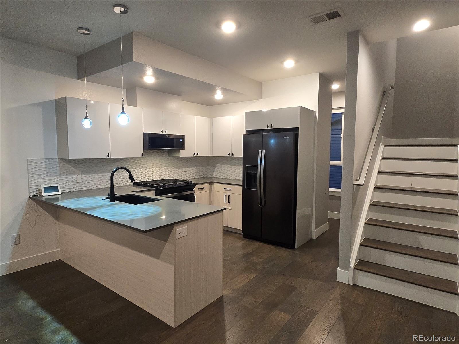 1284 Stuart Street Denver, CO 80204 - Photo 9 of 43 a kitchen with stainless steel appliances granite countertop a refrigerator and a sink