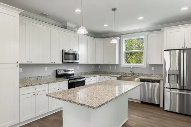 a kitchen with stainless steel appliances granite countertop a refrigerator and a sink