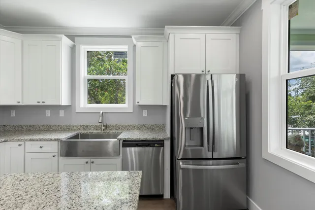 a kitchen with white cabinets and stainless steel appliances