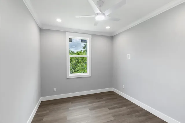 an empty room with wooden floor & closet area