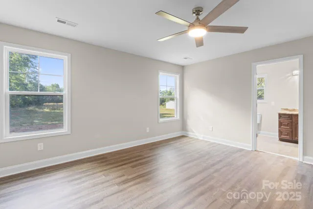 a view of an empty room with a window and a ceiling fan