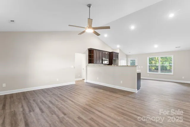 a view of a kitchen with wooden floor and a ceiling fan