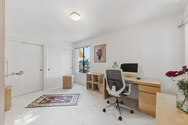 a view of a workspace with furniture and a window