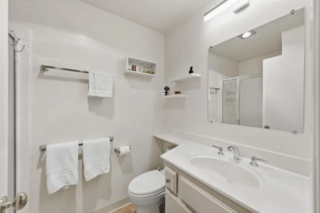 a bathroom with a sink toilet vanity and shower