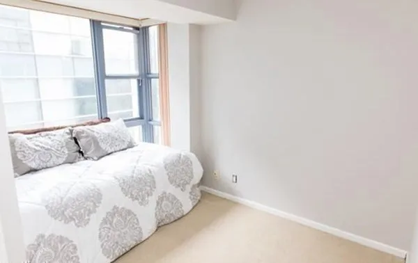 a large bed sitting in a bedroom next to a window