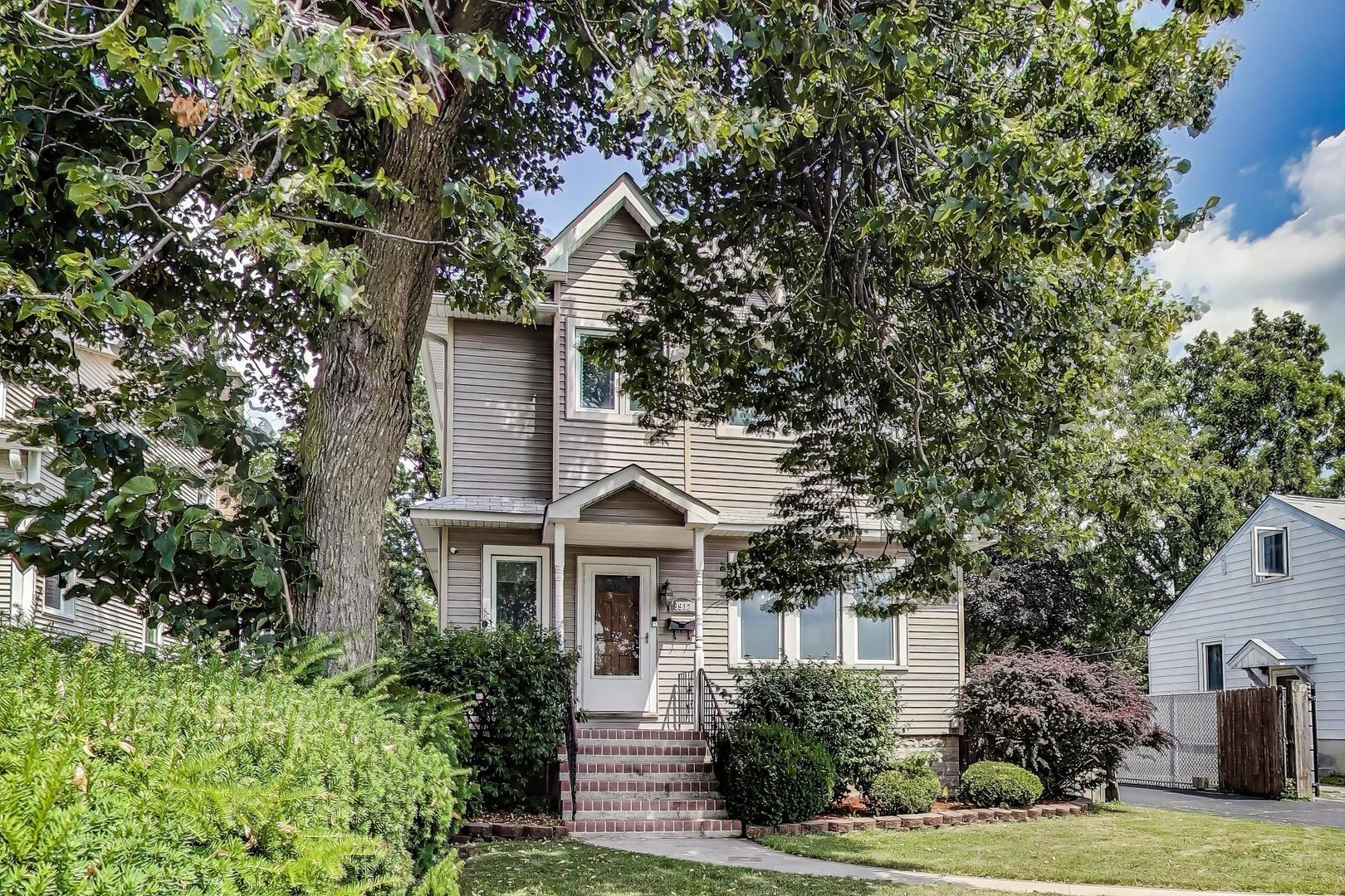 9912 Irving Park Road Schiller Park, IL 60176 - Photo 3 of 4 a front view of a house with a yard and potted plants