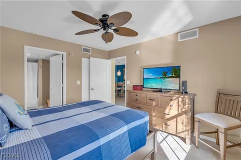 a bedroom with a bed and a flat screen tv on dresser