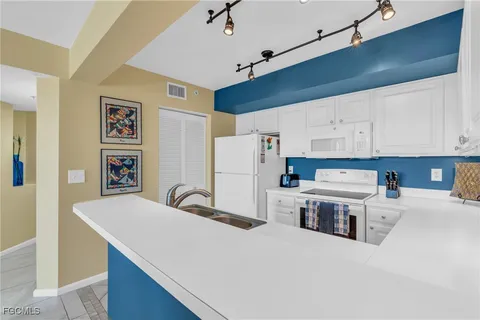 a kitchen with stainless steel appliances a refrigerator sink and white cabinets