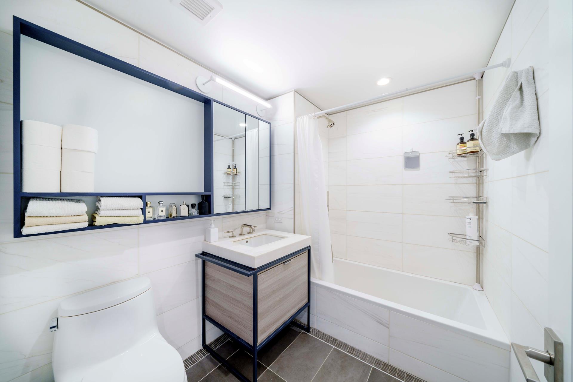 575 4th Avenue, Unit 2G Brooklyn, NY 11215 - Photo 6 of 7 a bathroom with a bathtub a mirror a sink and a shower