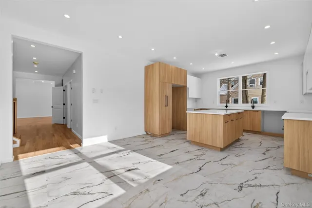a large kitchen with stainless steel appliances kitchen island granite countertop a sink and cabinets