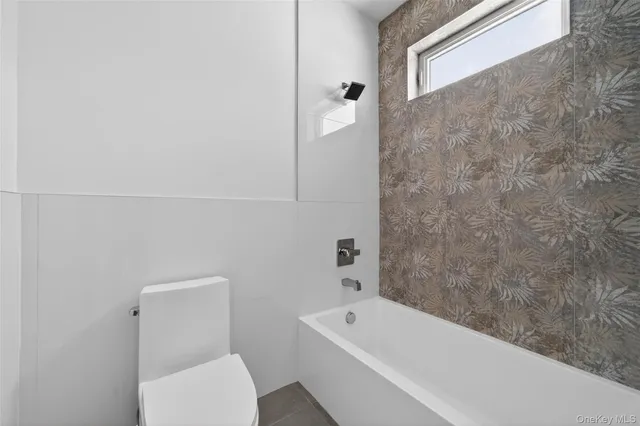 a bathroom with a toilet and bathtub