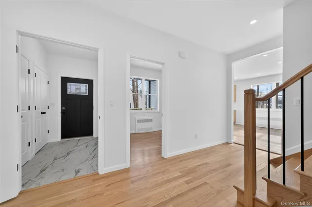 a view of a hallway with wooden floor and entryway