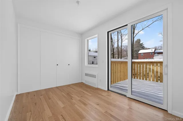 a view of a bedroom with wooden floor and windows