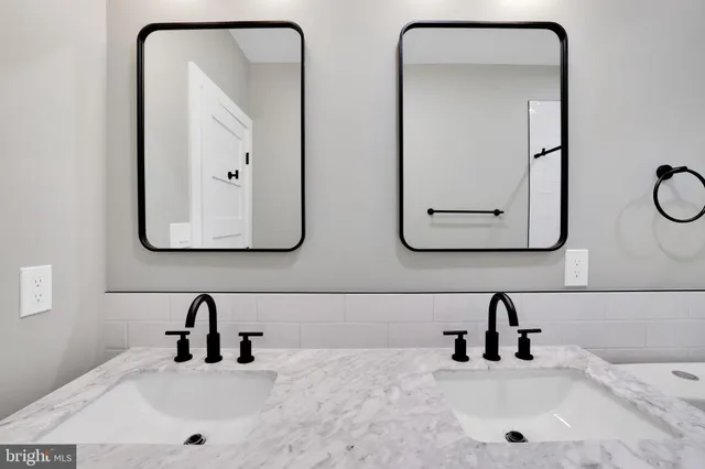 a bathroom with a double vanity sink toilet mirror and shower