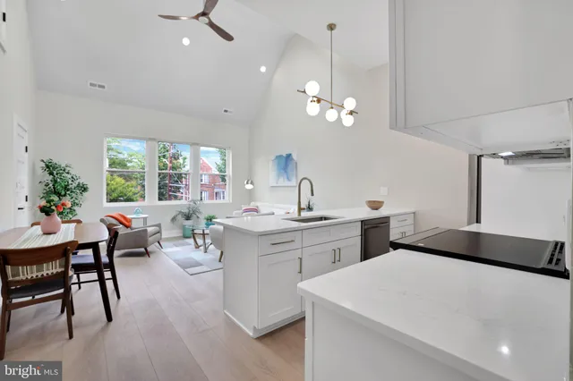 a living room with stainless steel appliances kitchen island furniture and a chandelier