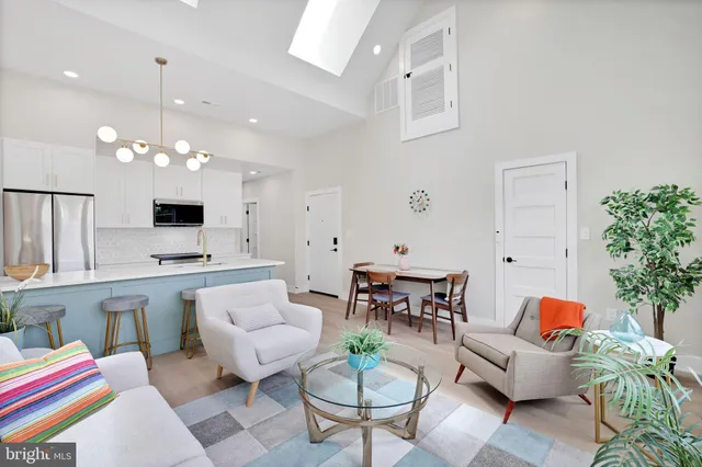 a living room with furniture a chandelier and a flat screen tv