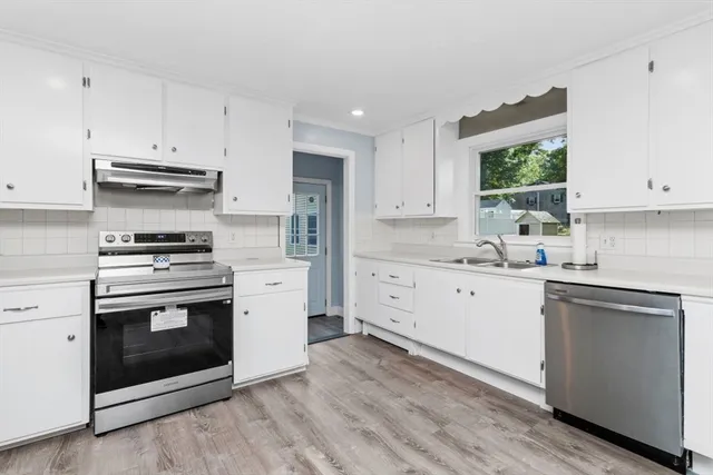 a kitchen with stainless steel appliances white cabinets and a sink