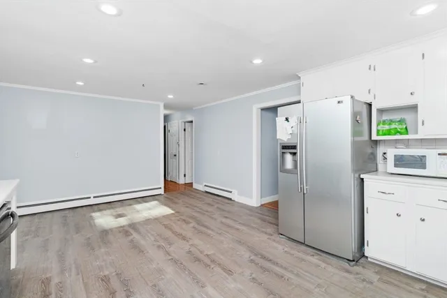 a view of a refrigerator in kitchen and wooden floor