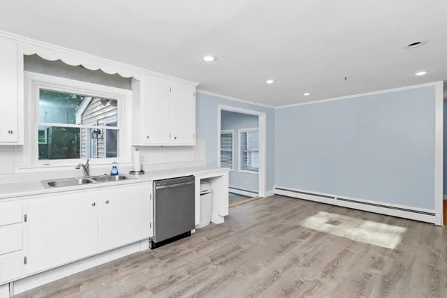 a large white kitchen with a sink and cabinets