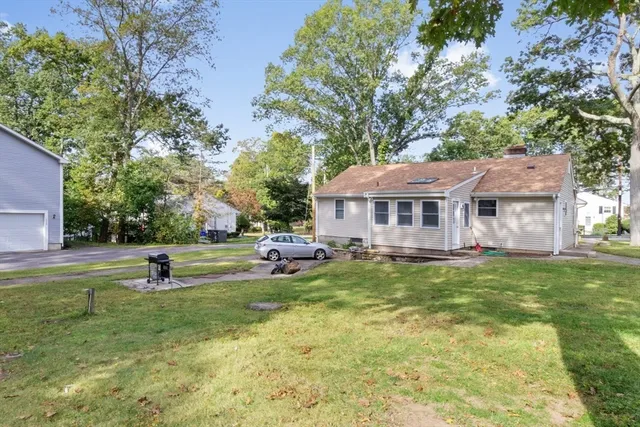 a view of a house with a big yard and sitting area