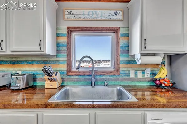 a kitchen with stainless steel appliances granite countertop a refrigerator a sink dishwasher a stove and white countertops with wooden floor