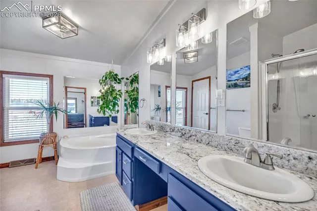 a en suite bathroom with a granite countertop sink and a mirror