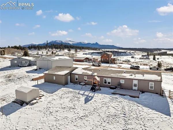 an aerial view of a house with a yard and city view