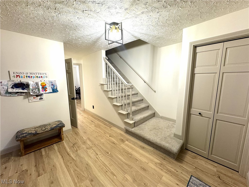 8359 Gibson Road Canfield, OH 44406 - Photo 8 of 27 Stairs featuring wood finished floors and a textured ceiling