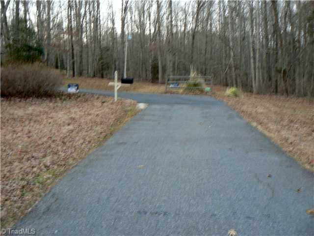2444 Scott Mountain Road Asheboro, NC 27205 - Photo 16 of 16 Entry. This is the approach to the house. The street ends at the property. The wooded acreage is all a part of the 3.94 acres. The house is to the left.